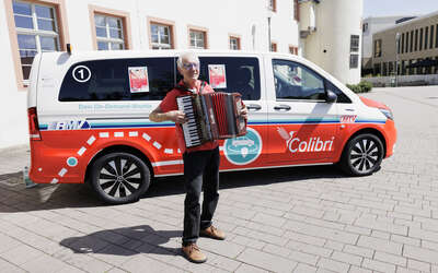 Mann spielt Akkordeon vor dem Colibri-Shuttle