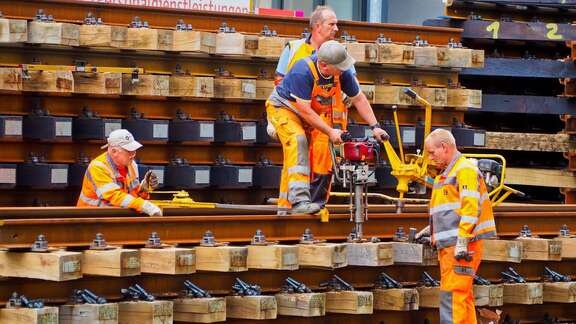 Vier Arbeiter beim Gleisbau