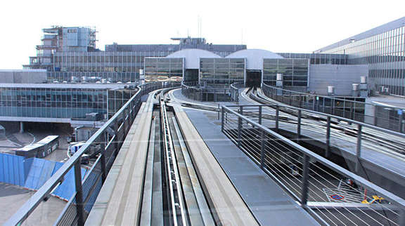 Vergrößerte Ansicht: Blick aus der SkyLine auf die Gleise über die Dächer der Flughafengebäude