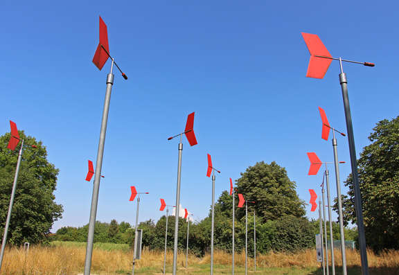 Vergrößerte Ansicht: Feld mit roten Windfahnen auf langen Masten