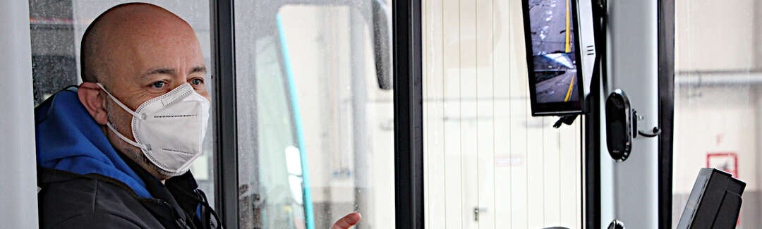 mittelalter Mann mit Corona-Maske auf dem Sitz des Busfahrers