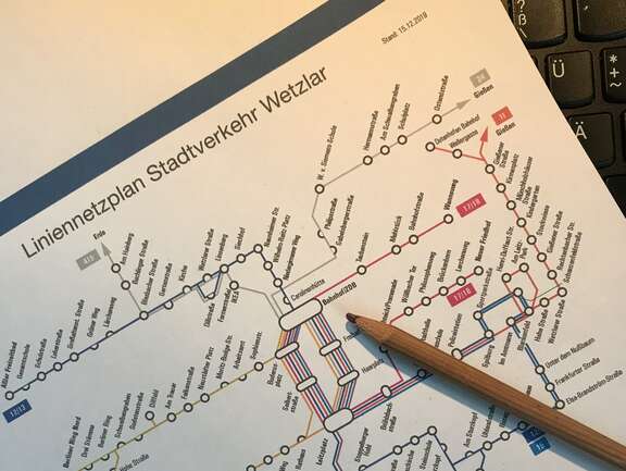 Das Bild zeigt den Liniennetzplan der Stadt Wetzlar mit einem darüber liegenden Bleistift als Symbol für die Neuerstellung des Nahverkehrsplanes.