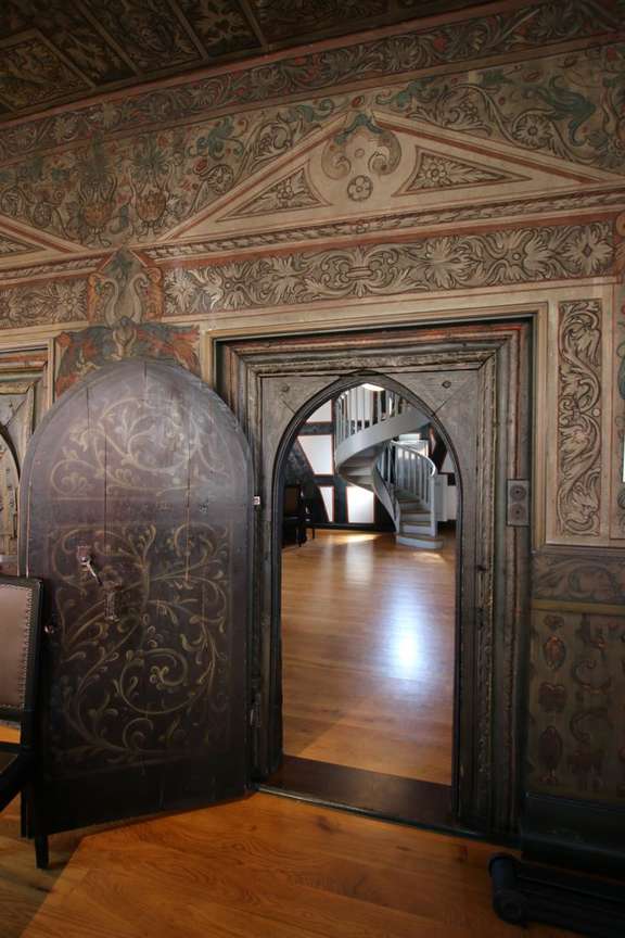 Vergrößerte Ansicht: Zimmer mit verzierter Holztür und bemalten Wänden