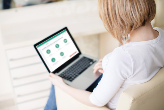 Woman with laptop on her knees showing the RMV website