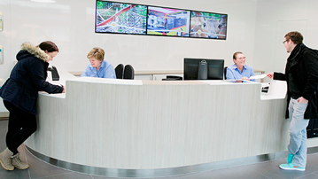 A service desk with two employees and two clients at each end