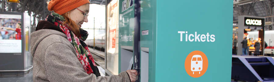 Eine Kundin bedient den Fahrkartenautomat
