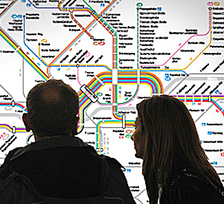 Paar steht vor einem Liniennetzplan und schaut ihn sich an