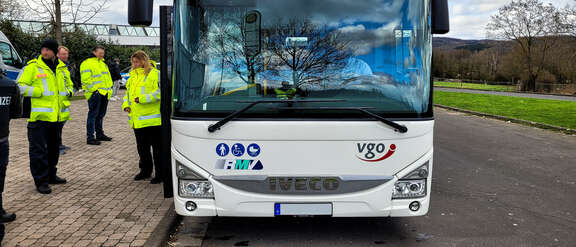Verkehrskontrolle des Regionalen Verkehrsdienstes (RVD) Gießen in Zusammenarbeit mit der VGO begutachten einen Bus vor der Schule
