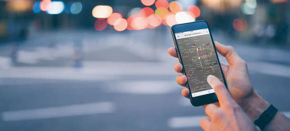 Stockfoto mit einem Handy, auf dem der interaktive Liniennetzplan zu sehen ist
