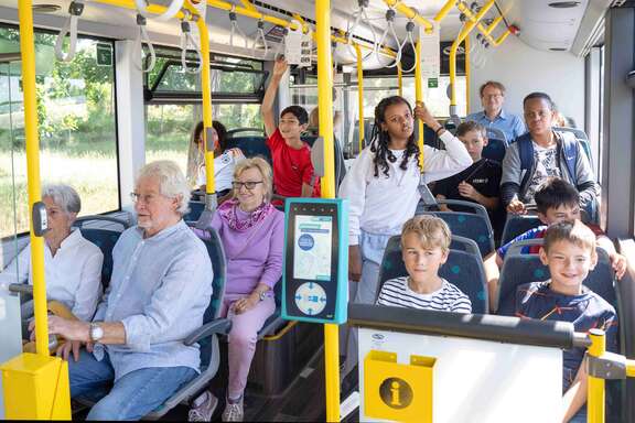 Senioren und Jugendliche in einem Bus.