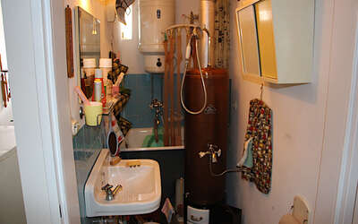 Minibadezimmer mit Waschbecken, Ofen und Sitzbadewanne