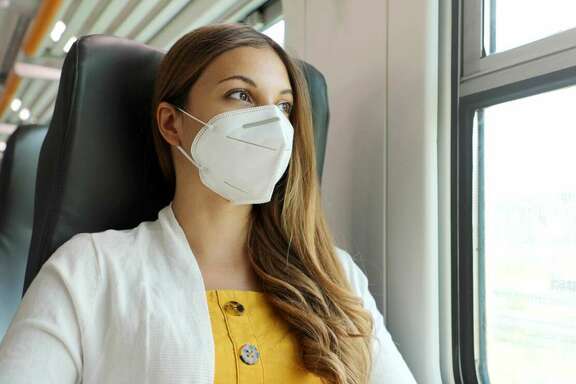 Frau im Zug trägt eine FFP2-Maske
