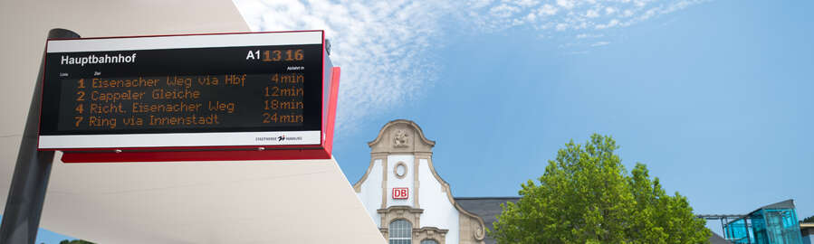 Digital display panel with bus information, in the background station building