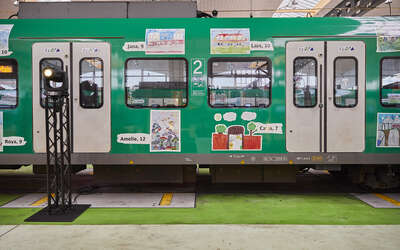 Grün lackierte S-Bahn mit Kinderbildern