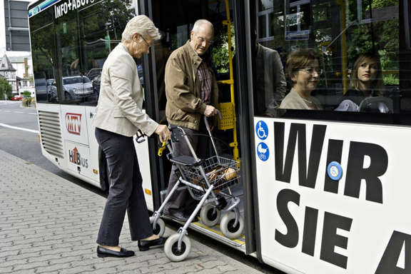 Vergrößerte Ansicht: Senioren mit Rollator steigen in einen Bus.