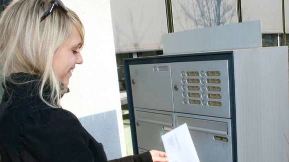 Woman inserting a letter into the letterbox