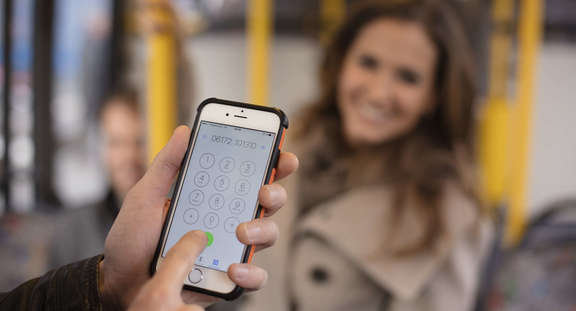 Smartphone im Bus mit Rufnummer des Anrufsammeltaxis: 061 72 10 13 10 