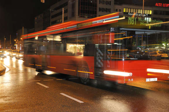 Red bus number N81 driving by night