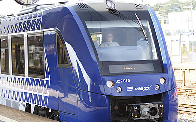 Vergrößerte Ansicht: blauer Zug Coradia Lint54 / Lint81 am Bahnsteig unter einer Bahnhofsuhr stehend