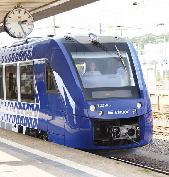 Vergrößerte Ansicht: blauer Zug Coradia Lint54 / Lint81 am Bahnsteig unter einer Bahnhofsuhr stehend