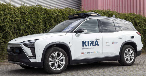 KIRA Weißer SUV mit KIRA-Schriftzug auf der Vordertür und Sensoren auf dem Dach