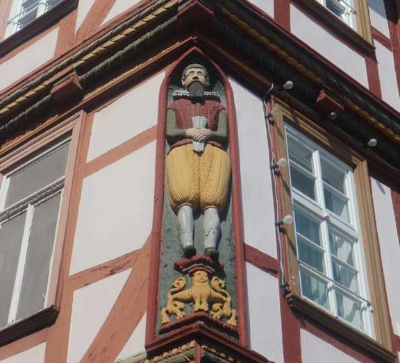 geschnitzte Figuren an der Ecke einer Fachwerk-Haus-Fassade