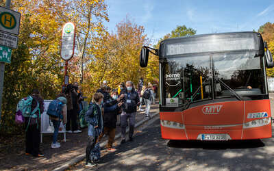 Linie 816 wartet an einer Haltestelle mit Schülern und Buslotsen