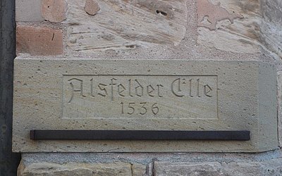 Vergrößerte Ansicht: Ausschnitt alte Steinmauer mit Aufschrift: Alsfelder Elle 1536, darunter altes Ellenmaß