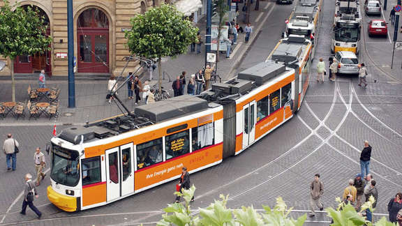 Orange and white tram turning around a corner seen from above