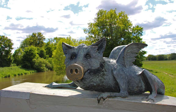 Bronzeskulptur: Schwein mit Flügeln und Drachenklauen von vorne aufgenommen