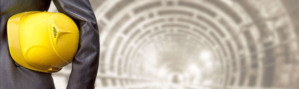 Nahaufnahme Mann mit gelben Helm, auf Gleisen im Tunnel