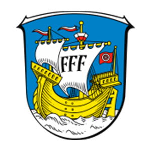 Wappen Flörsheim: Blauer Schild mit silbernen Wellen, darauf ein goldenes Schiff mit silbernen Segeln und silbern-roter Beflaggung; Hauptsegel zeigt drei schwarze F, Heckflagge das Mainzer Rad (silbernes Rad auf rotem Grund).