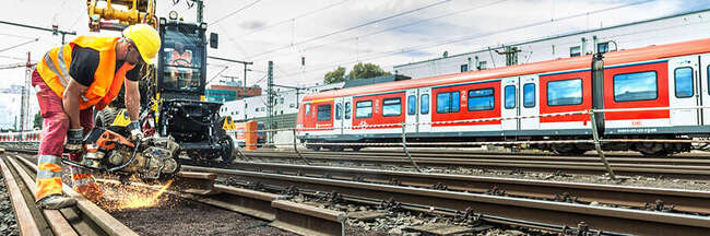 Ein Bauarbeiter führt Schweißarbeiten an Bahngleisen durch