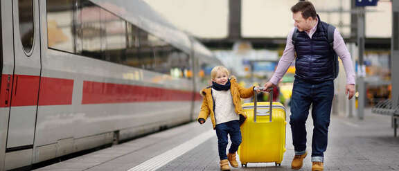 Father and son with suitcases on the platform