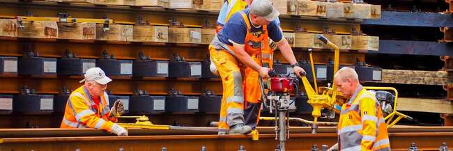 Vier Arbeiter beim Gleisbau