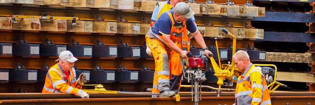 Vier Arbeiter beim Gleisbau