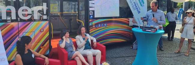 Drei Frauen sitzen auf dem roten Sofa vor dem Mobilitätsbus.