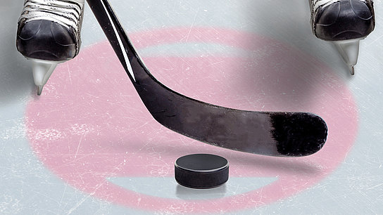 Detailaufnahme eines Eishockeyspielers mit Schlittschuhen, Schläger und Puck.