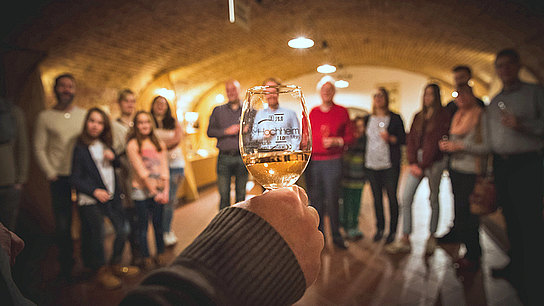 Eine Besuchergruppe während eines Vortrags über Wein