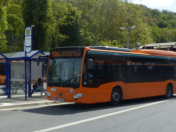 ein orangener Bus der Linie 530 Herborn Bahnhof - ZOB steht an einer Haltestelle