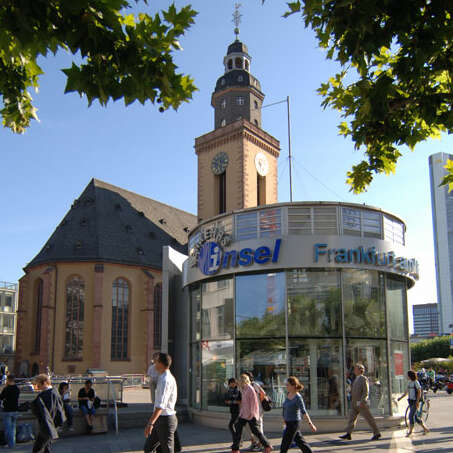Das Gebäude der Verkehrsinsel an der Hauptwache mit der Katharinenkirche im Hintergrund