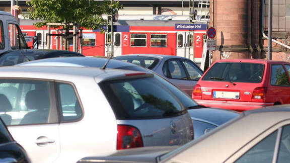 Vergrößerte Ansicht: parkende Autos vor einem S-Bahnhof