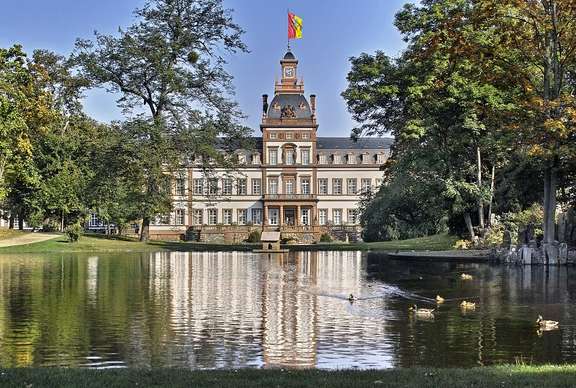 Weiher mit Bäumen gesäumt. Barockschloss im Hintergrund