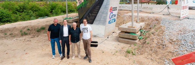 Vor dem Brückenpfeiler (v.l.n.r.): Prof. Knut Ringat (RMV), Julien Zamberk (Eintracht Frankfurt), Horst Amann (RTW Planungsgesellschaft) und der Frankfurter Mobilitätsdezernent Wolfgang Siefert (v. l.) vor dem von Fan-Vertretern der Eintracht Frankfurt gestalteten Mural am Frankfurter Waldstadion.