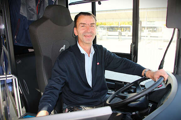 Ein Mann sitzt hinterm Lenkrad eines Busses