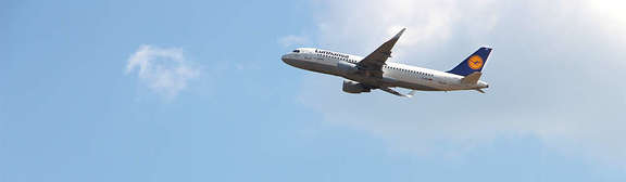 Vergrößerte Ansicht: eine Lufthansa-Maschine startet in den blauen Himmel