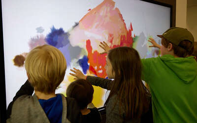 Kinder betasten ein modernes Gemälde.