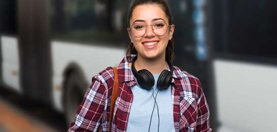 a Teenager girl with a skateboard behind her back