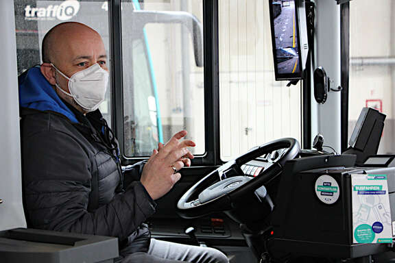 mittelalter Mann mit Corona-Maske auf dem Sitz des Busfahrers