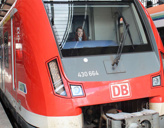 Im Führerstand einer S-Bahn sitzt eine Lokführerin